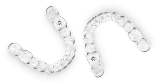 Clear orthodontic aligners arranged in curved rows showing progression of dental treatment stages.
